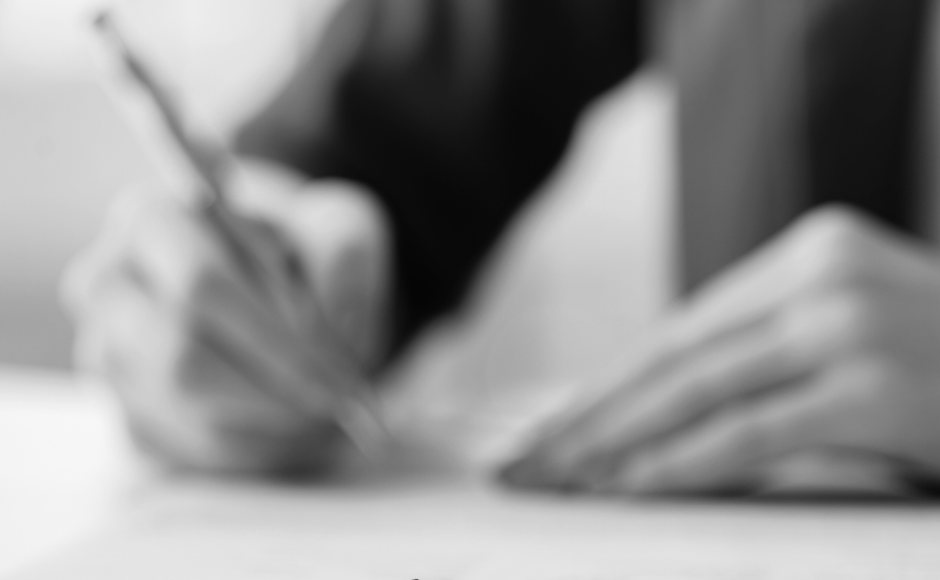 A man signing a divorce contract with two rings focused at the front